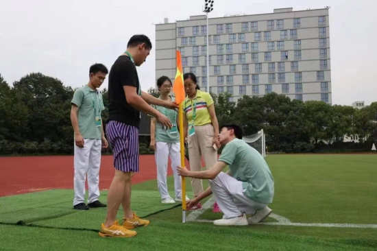  图：董佳乐以及其他场馆志愿者进行赛场维护